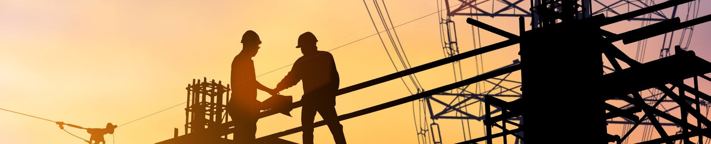 Silhouette Good deal two engineer business people shaking hands  heavy industry and safety at work concept over blurred natural background sunset pastel.