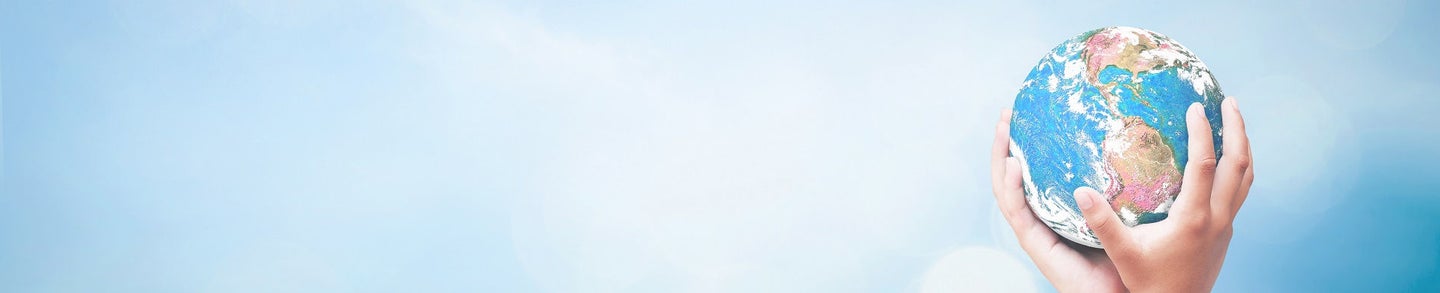 World environment day concept: Two human hands holding earth globe over blurred blue sky and water background. Elements of this image furnished by NASA